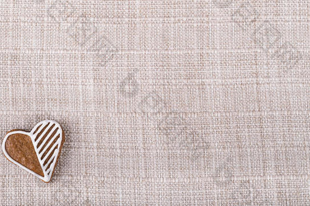 甜蜜的姜饼心好运气米色布背景织物纹理hand-decorated糕点复制空间