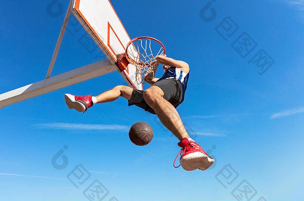 大满贯扣篮一边视图年轻的篮球球员使大满贯扣篮