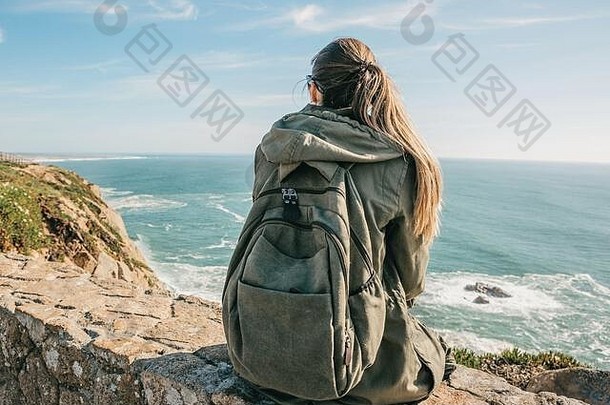 女孩旅游背包孤独坐在海