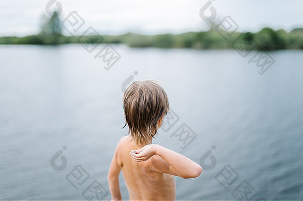 男孩扔石头水海滩热夏天一天有趣的假期男孩玩湖