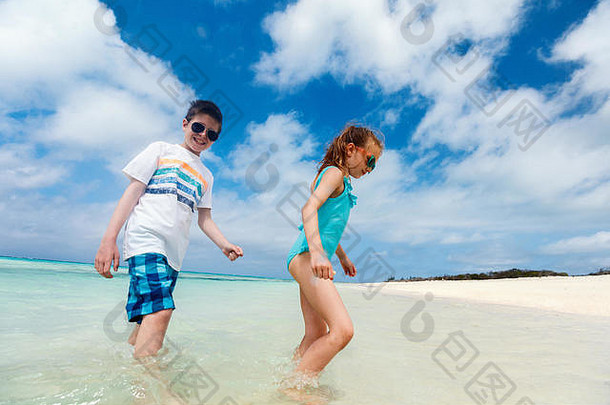 孩子们有趣的热带海滩热带夏天假期玩浅水