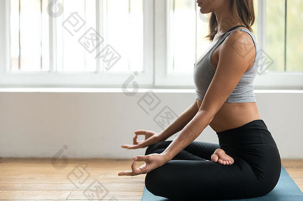 年轻的运动女人练习瑜伽阿尔达padmasana锻炼