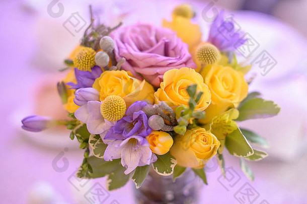 花俏的彩色的花安排明亮的黄色的紫色的玫瑰美丽的装饰表格居于核心地位婚礼正式的事件