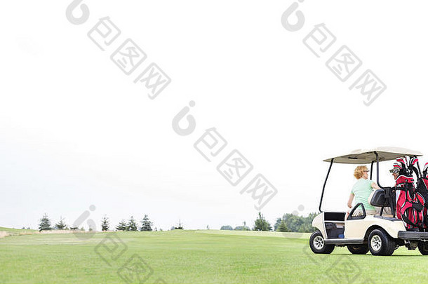 夫妇坐着高尔夫球车清晰的天空