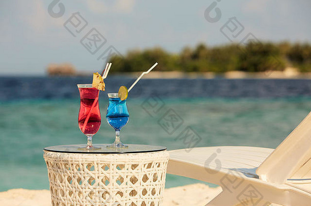 眼镜鸡尾酒表格海滩板凳上甲板椅子蓝色的海洋白色沙子背景马尔代夫