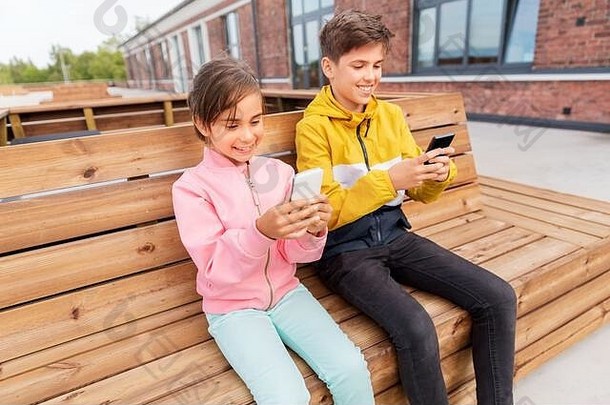 孩子们智能<strong>手机</strong>坐着街板凳上