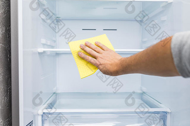 男人的手黄色的橡胶保护手套清洁白色开放空冰箱绿色破布