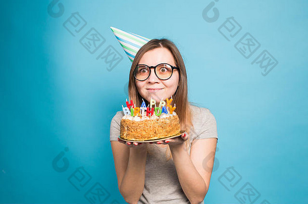关闭有趣的积极的女孩眼镜问候纸他持有快乐生日蛋糕手站蓝色的背景