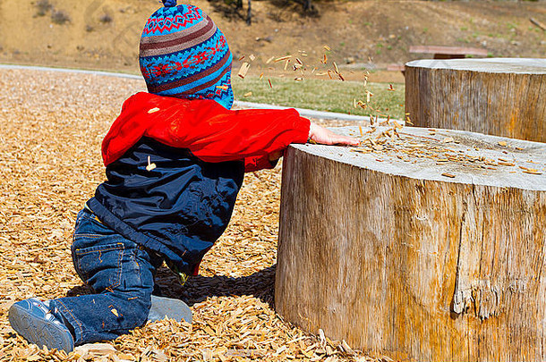 一岁男孩戏剧公园在户外木芯片结构娱乐