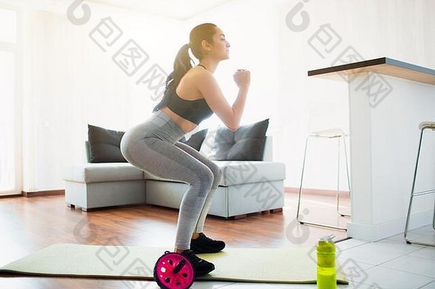 年轻的女人体育运动锻炼房间检疫蹲锻炼瑜伽席房间集中锻炼
