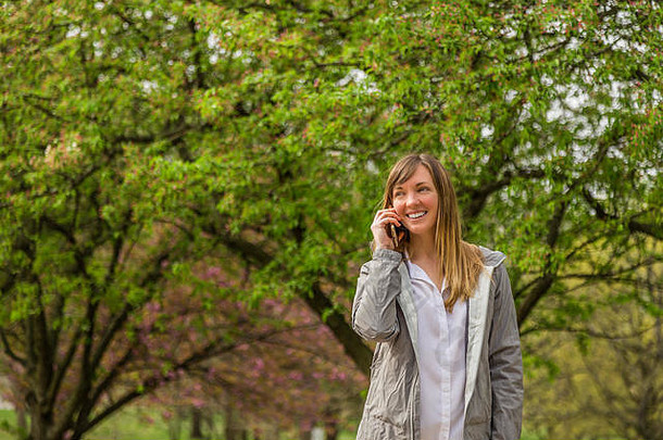 年轻的女人会说话的电话公园