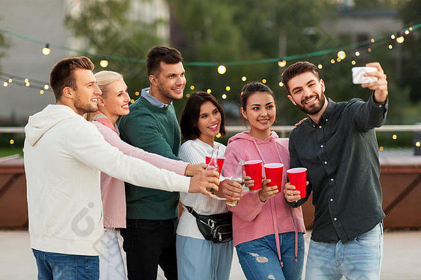 朋友饮料采取自拍屋顶聚会，派对