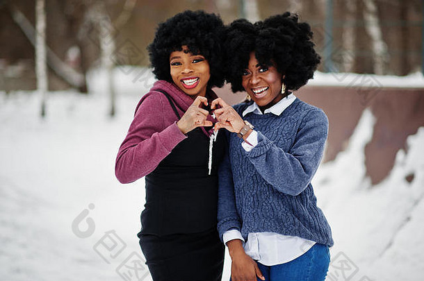 卷曲的头发非洲美国女人穿毛衣构成冬天一天显示心手指