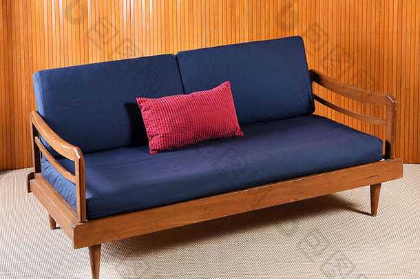 高角生活视图古董木沙发海军蓝色的红色的垫子生活房间米色地毯木墙镶板