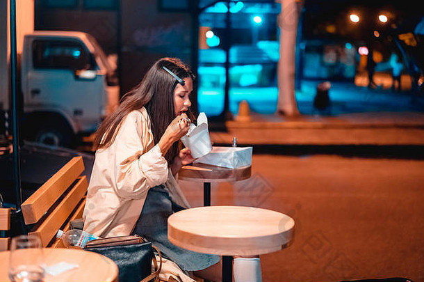 女孩吃快食物街晚上城市