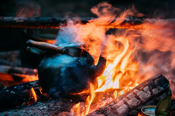 黑色的复古的铁营水壶沸腾水火森林明亮的火焰火篝火黄昏晚上