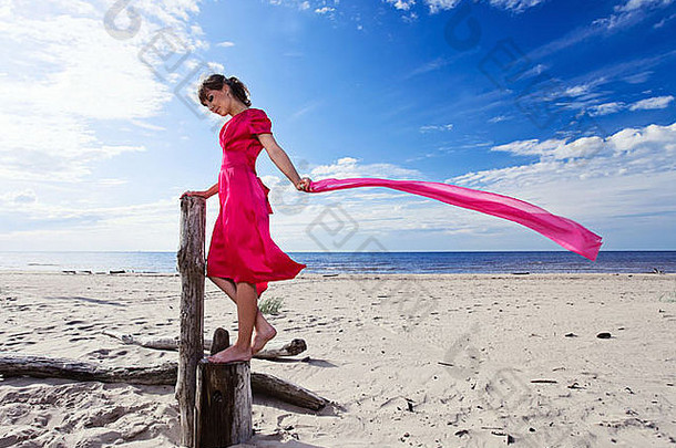 年轻的女人红色的衣服海滩