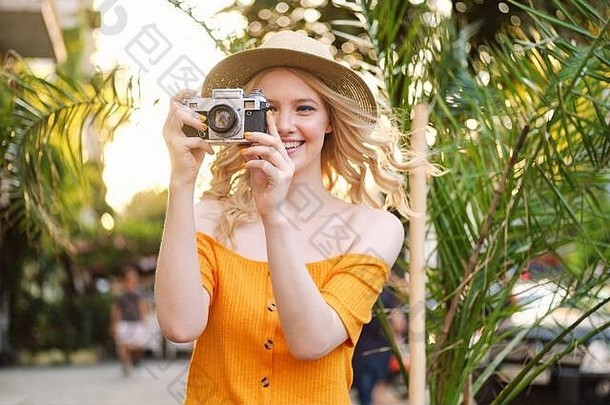有吸引力的迷人的微笑金发碧眼的女孩他幸福的采取照片复古的相机街