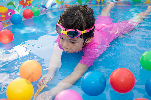 婴儿女孩粉红色的西装玩水球蓝色的小孩池