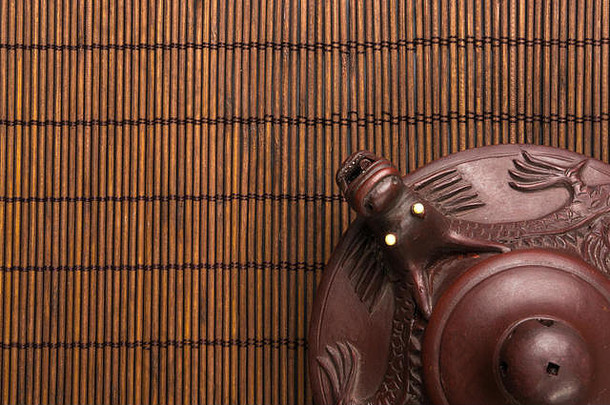 棕色（的）中国人茶壶宜兴粘土传统的点缀竹子席