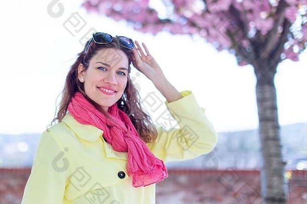 年轻的红色头发的人女人粉红色的围巾走公园春天樱花