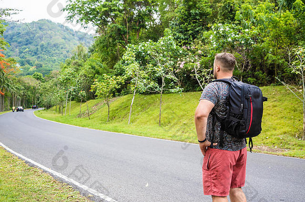 英俊的热带森林旅行者年轻的男人。背包路泰国森林男人。走热带路享受的观点