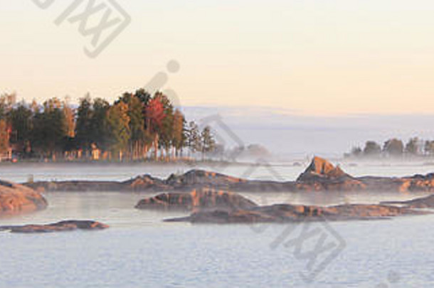 岩石形成色彩斑斓的树有雾的秋天早....海岸湖习惯最大湖瑞典