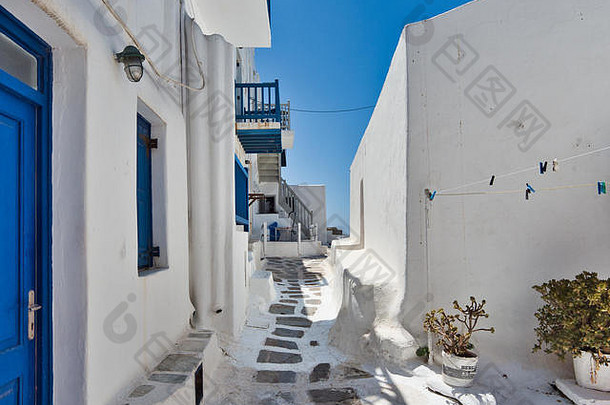 狭窄的石头路径龚建筑白色墙街小小镇万里无云的蓝色的天空米克诺斯岛希腊