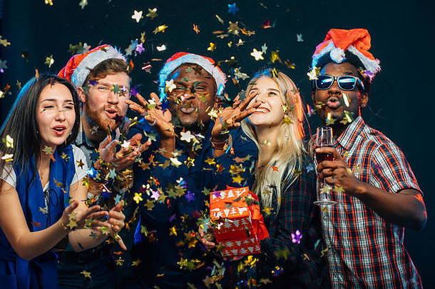 朋友一年的聚会，派对穿圣诞老人帽子跳舞吹五彩纸屑