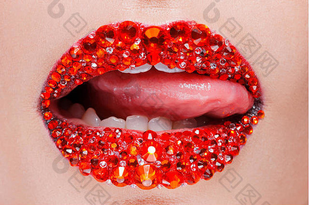 红色的嘴唇覆盖莱茵石美丽的女人红色的口红嘴唇舌头舔了舔嘴唇