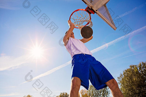 大满贯扣篮一边视图年轻的篮球球员使大满贯扣篮
