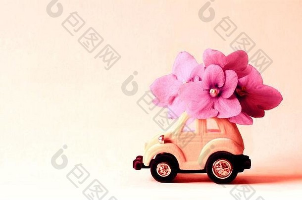 卡玩具车交付花束花粉红色的背景