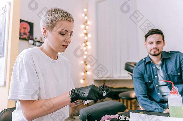 短发金发碧眼的女人穿黑色的手套准备墨水机
