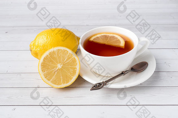 Herbal黑色的茶白色杯蜂蜜Jar新鲜的柠檬白色木背景