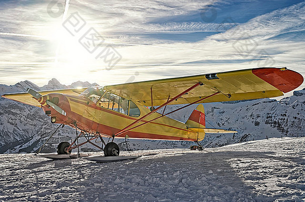 黄色的飞机山机场瑞士阿尔卑斯山脉前面闪亮的太阳