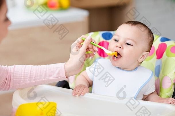 <strong>婴儿</strong>男孩吃健康的早餐坐着高椅子