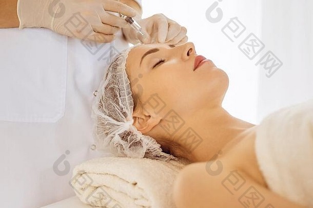 美丽的女人接收美注射关闭眼睛美容师医生手美过程女脸注射器化妆品