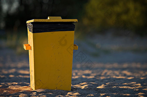 黄色的垃圾容器沙子