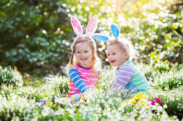 孩子们复活节蛋亨特盛开的<strong>春天</strong>花园孩子们兔子耳朵搜索色彩斑斓的鸡蛋雪下降花草地蹒跚学步的男孩