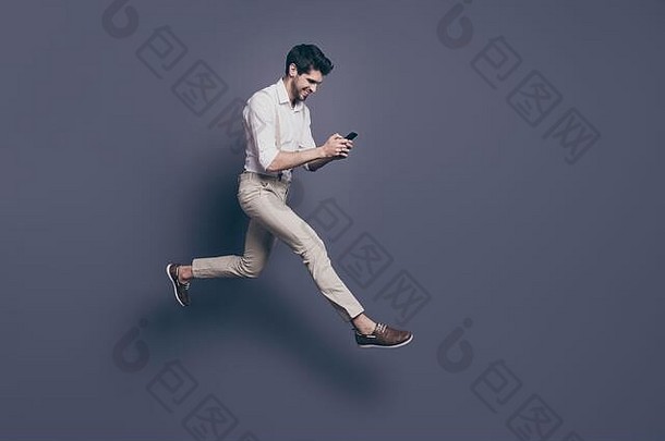完整的长度照片快乐的的家伙消息女朋友读短信智能<strong>手机</strong>享受跳运行日期穿白色衬衫装孤立的灰色