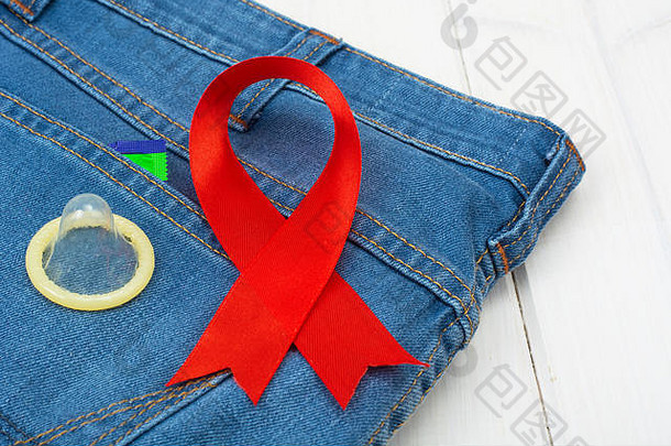 红色的丝带避孕套蓝色的牛仔裤背景概念意识保护艾滋病艾滋病毒12月