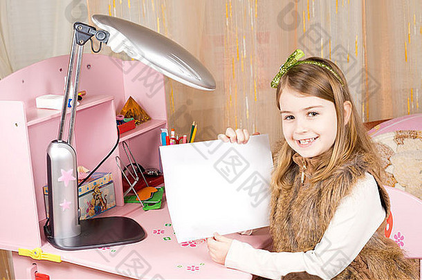 可爱的快乐漂亮的女孩坐着粉红色的桌子上卧室显示表空白纸相机艺术作品文本