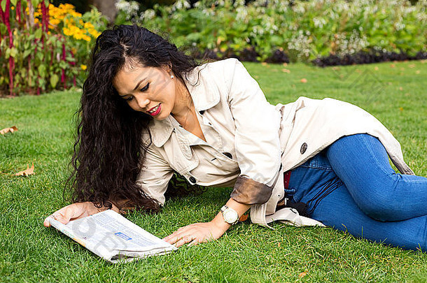 年轻的女人阅读纸公园