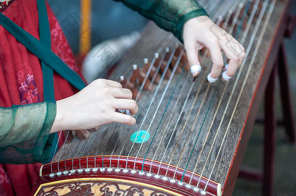 重庆中国6月女人玩古筝传统的中国人音乐字符串仪器