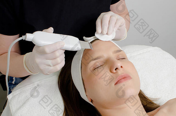 美丽的女人接收超声波面部去死皮过程超声波清洁脸美沙龙现代超声波皮肤设备