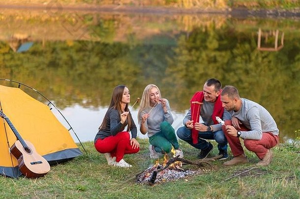 旅行旅游徒步旅行野餐人概念集团快乐朋友煎香肠篝火湖