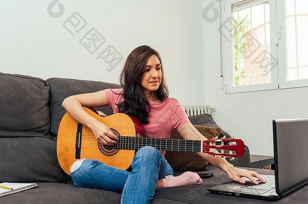 女人采取吉他教训在线沙发上首页在线学习概念