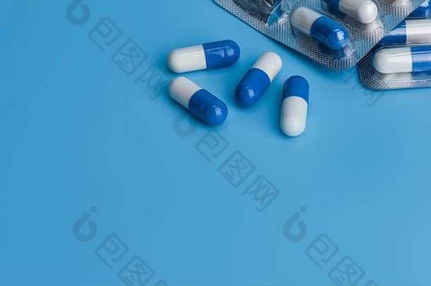 药片蓝色的背景复制空间蓝色的白色药片胶囊溢出药丸泡
