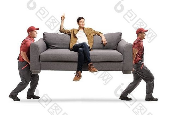 搬家公司携带沙发年轻的男人。坐着指出孤立的白色背景