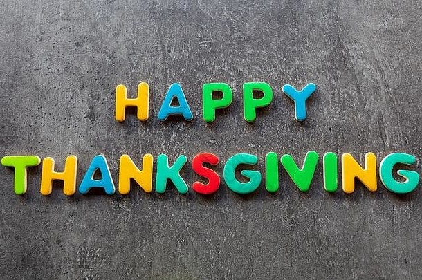 快乐感恩节单词写色彩斑斓的信花岗岩背景前视图